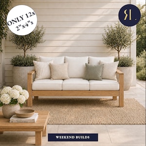 May include: A wooden outdoor sofa with white cushions and decorative pillows. The sofa sits on a neutral-colored rug, with a wooden coffee table and potted plants nearby. The text "WEEKEND BUILDS" is at the bottom.