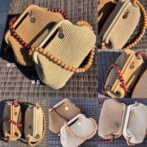 May include: A collection of handmade crochet handbags in various shades of beige and tan. Each bag features a wooden beaded handle and a metal clasp. The bags are displayed on a textured surface, showcasing their unique textures and designs.