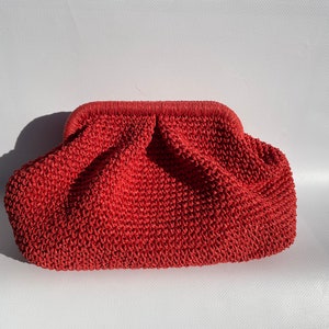 Peut inclure: Une pochette de soirée en crochet rouge corail avec une fermeture à fermoir métallique.