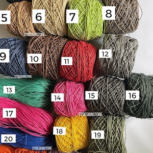 Pu&ograve; includere: Ventitr&eacute; gomitoli di filato in vari colori, tra cui nero, bianco, marrone, verde, rosso, rosa, blu, giallo, arancione e viola. Il filato &egrave; disposto in file e numerato da 1 a 23.