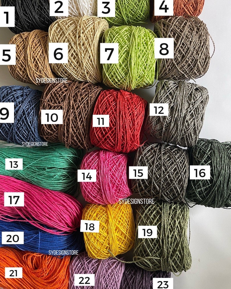 Pu&ograve; includere: Ventitr&eacute; gomitoli di filato in vari colori, tra cui nero, bianco, marrone, verde, rosso, rosa, blu, giallo, arancione e viola. Il filato &egrave; disposto in file e numerato da 1 a 23.