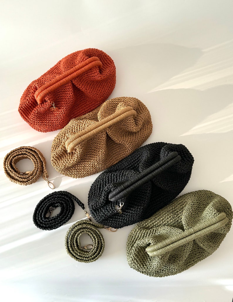 May include: Four crocheted handbags in different colors: orange, brown, black, and green. Each bag has a unique woven texture and a top handle. The bags are arranged in a row on a white surface.