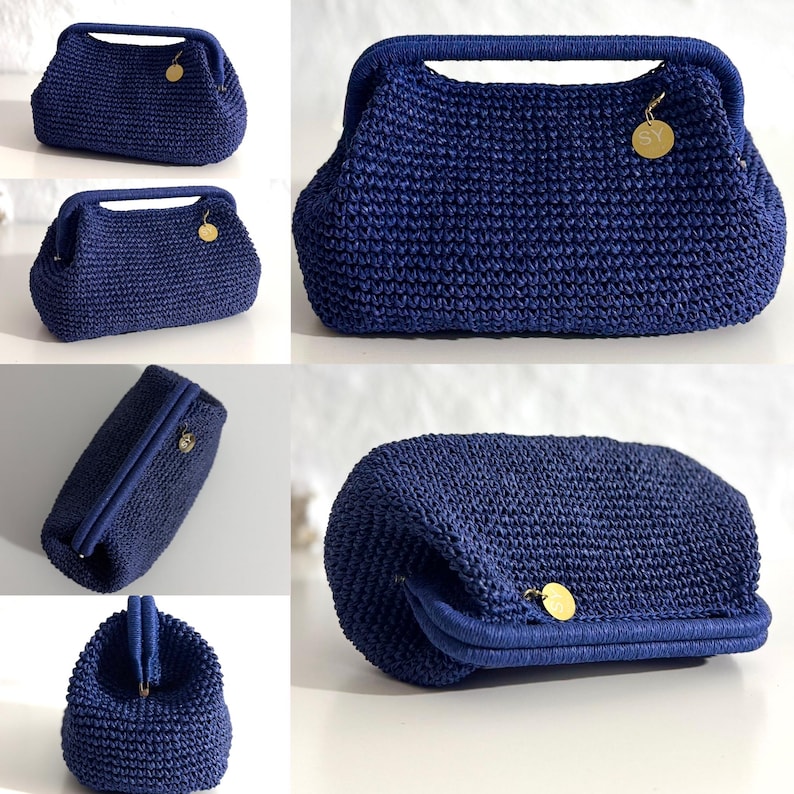 May include: A navy blue crochet handbag with a structured frame and a top handle. The bag features a gold-colored charm and a clasp closure. The crochet pattern is visible throughout the bag's exterior.