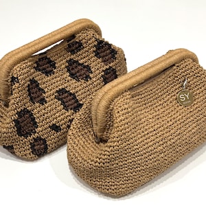 May include: Two crocheted handbags, one with a brown and black leopard print and the other in a solid brown color. Both bags have a top handle and a small metal tag with the letters "SY" on it.