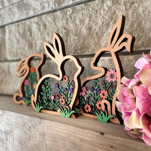 Trio primaverile artigianale: coniglietti pasquali in pioppo e cedro, design reversibile. Legno naturale con fiori primaverili dipinti a mano.