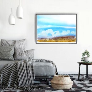 May include: A watercolor painting of a landscape with a blue sky and white clouds. The foreground is a field of tall grass in shades of brown and yellow.