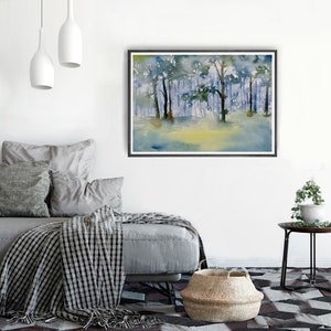 May include: A watercolor painting of a forest scene with trees in shades of blue and green. The painting is framed in a black frame and is hanging on a white wall.