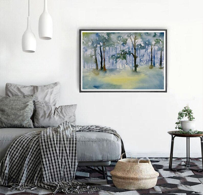 May include: A watercolor painting of a forest scene with trees in shades of blue and green. The painting is framed in a black frame and is hanging on a white wall.