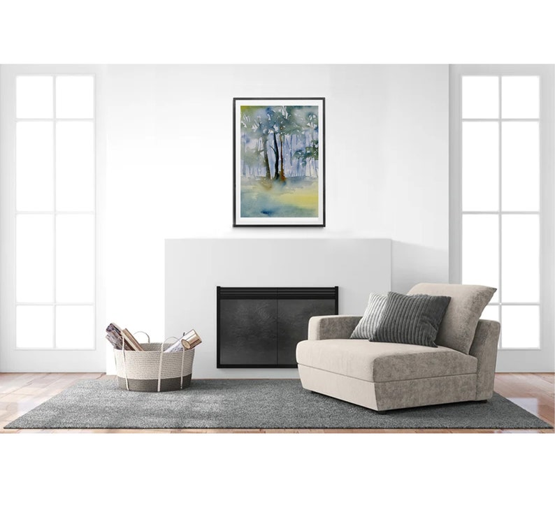 May include: A framed watercolor painting of a forest scene with trees and a blue sky. The painting is in a black frame and is hanging on a white wall above a fireplace.