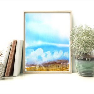 May include: A watercolor painting of a landscape with a blue sky, white clouds, and a field of tall grass. The painting is framed in a light wood frame.