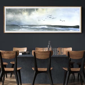 Peut inclure: Une peinture à l'aquarelle représentant un paysage marin avec un vol d'oiseaux survolant l'océan. Le ciel est bleu clair avec des nuages gris. L'océan est bleu foncé avec des vagues blanches.