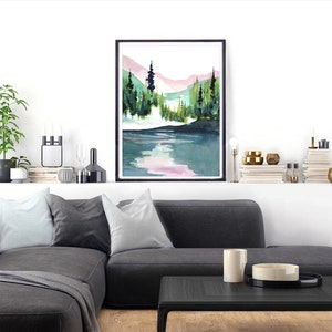 Pode incluir: Pintura em aquarela de uma cena de floresta com um lago em primeiro plano. As &aacute;rvores s&atilde;o verdes e as montanhas ao fundo s&atilde;o rosa e azuis.