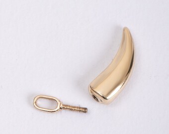 May include: Gold-toned metal tooth charm with a screw-on loop for attaching to a necklace or bracelet.