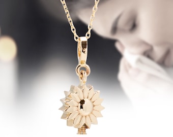 May include: A gold necklace with a sunflower pendant. The pendant has a small keyhole in the center.