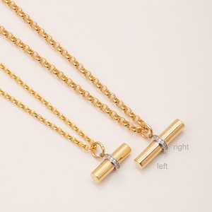 May include: Two gold necklaces with a bar pendant featuring a row of small diamonds. The pendant on the left necklace is smaller than the pendant on the right necklace. The text "left" and "right" is written below the pendants.
