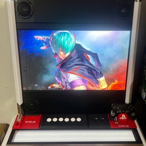 May include: A red and black arcade cabinet with a screen displaying a video game character. The cabinet has a white logo that says "VEWLIX" and a black control panel with buttons and a joystick. The cabinet is lit up with white lights.