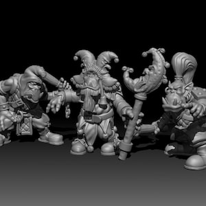 Könnte beinhalten: Drei Miniatur-Fantasyfiguren, eine mit einer Narrenmütze und einem Bart, eine mit einer Kapuze und eine mit einem gehörnten Helm und einem Halbmondstab.