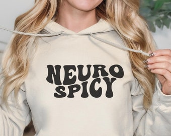 May include: A sand-colored hoodie with a black graphic that says "NEURO SPICY" in a retro font.