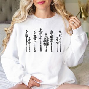 May include: White sweatshirt with a black graphic print of a row of trees. The trees are stylized and have a distressed look.