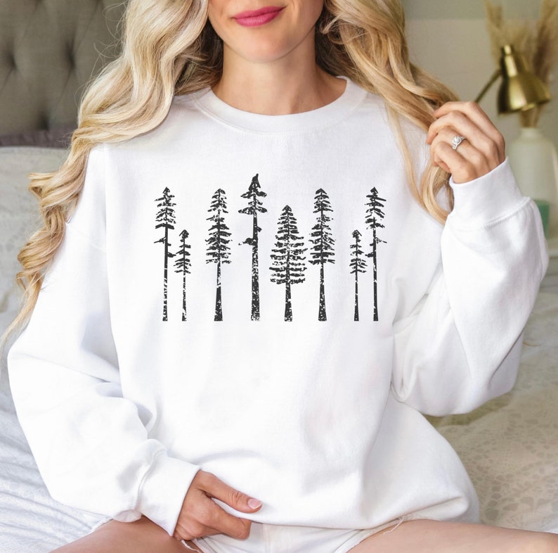May include: White sweatshirt with a black graphic print of a row of trees. The trees are stylized and have a distressed look.