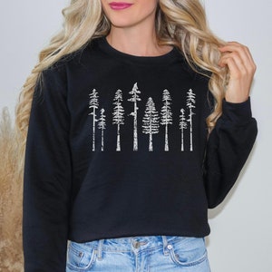 May include: Black sweatshirt with a white graphic print of a row of stylized trees.