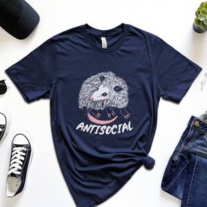 May include: A navy blue t-shirt with a graphic of a possum and the text "Antisocial".