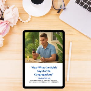 Op de afbeelding: Een digitale tablet toont een man die een smartphone gebruikt en schrijft. Het scherm toont tekst: "Hoor wat de Geest tegen de gemeenten zegt" en "Openbaring 3:22". De tablet ligt op een houten oppervlak met een koffiekopje, bloemen en een laptop.