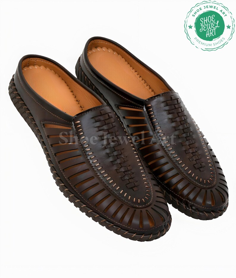 May include: A pair of brown leather slip-on shoes with intricate woven and cut-out designs. The shoes have a light brown interior and a stitched, textured sole. The image includes a logo that says "Shoe Jewel Art Premium Shoes".