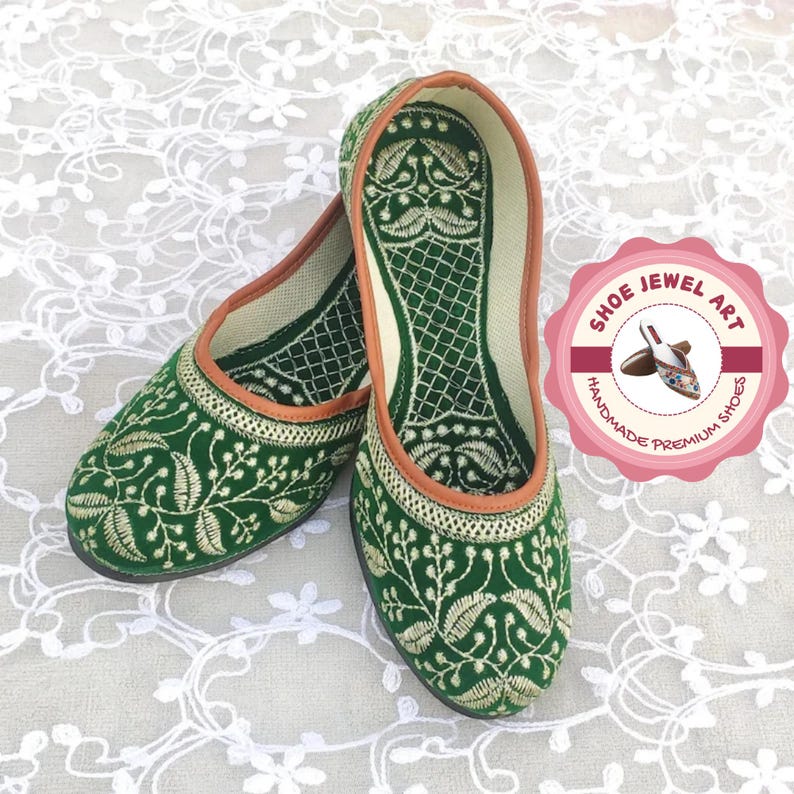 K&ouml;nnte beinhalten: Ein Paar gr&uuml;ne, bestickte Ballerinas mit floralem Design. Die Schuhe haben eine braune Einfassung und ein wei&szlig;es Innenfutter. Das Bild enth&auml;lt ein rosa-wei&szlig;es Logo mit der Aufschrift "Shoe Jewel Art, Handmade Premium Shoes."