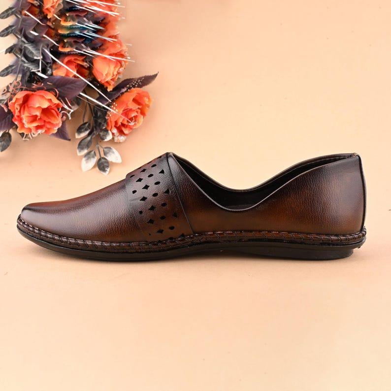 Op de afbeelding: Bruine leren schoen met een spitse neus en decoratieve uitgesneden details. De schoen heeft een gestikte zool en een laag profiel, geschikt voor casual of formele gelegenheden. De schoen wordt gepresenteerd op een neutrale achtergrond.