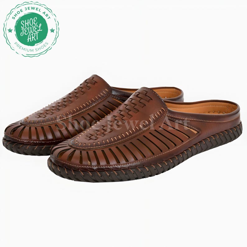 May include: A pair of brown leather slip-on shoes. The shoes have a woven design on the top and cut-out details on the sides. The soles are dark brown with a textured pattern. The shoes are displayed on a white background.