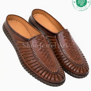 May include: A pair of brown leather sandals with a woven design on the top and cut-out details. The sandals have a stitched sole and a light brown interior. The brand logo "Shoe Jewel Art" is visible.