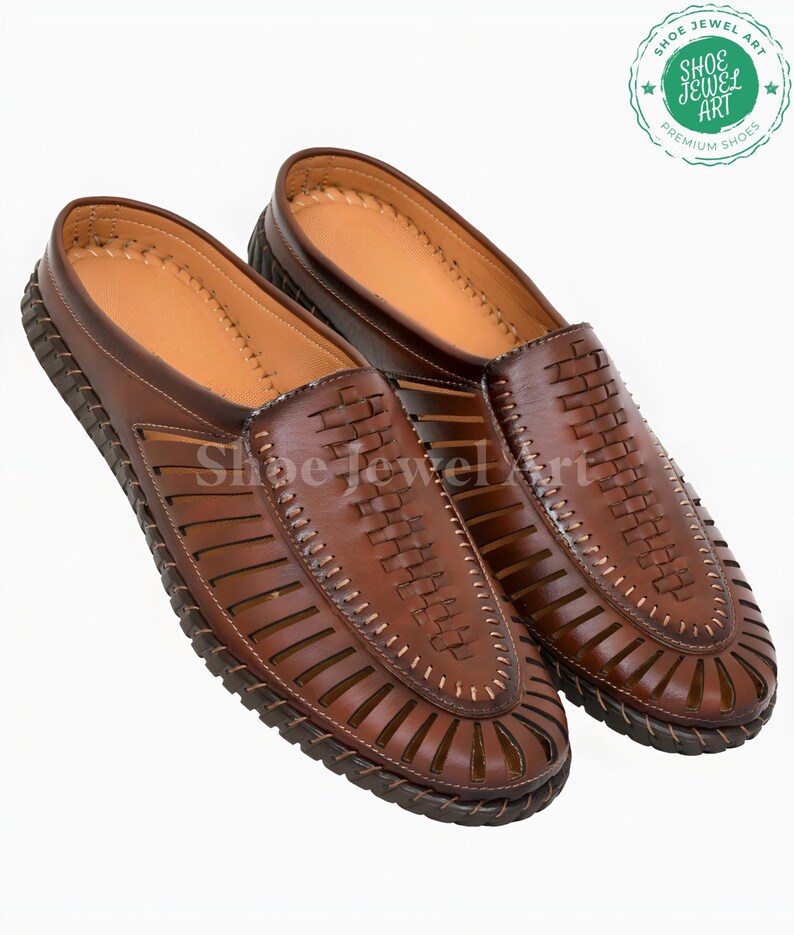 May include: A pair of brown leather sandals with a woven design on the top and cut-out details. The sandals have a stitched sole and a light brown interior. The brand logo "Shoe Jewel Art" is visible.