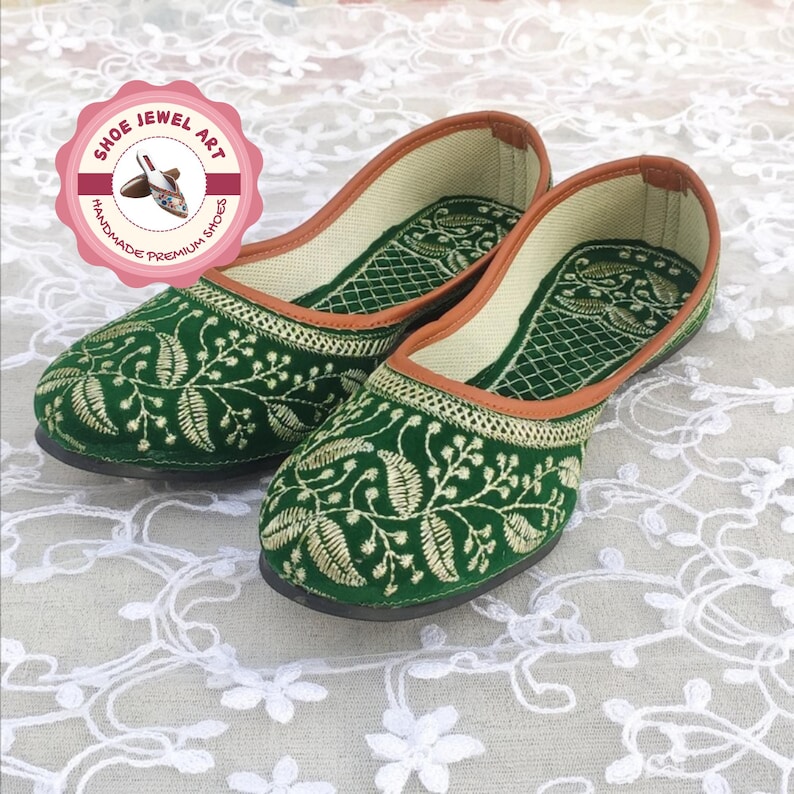 K&ouml;nnte beinhalten: Ein Paar gr&uuml;ne Samt-Ballerinas mit aufwendiger goldener Stickerei mit einem Blattdesign. Die Schuhe haben eine braune Einfassung und ein cremefarbenes Innenfutter. Das Bild enth&auml;lt ein Logo mit der Aufschrift "Shoe Jewel Art, Handmade Premium Shoes".