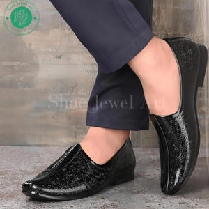 May include: Pair of black patent leather slip-on shoes with a delicate embossed design. The shoes have a high-shine finish and a low heel. The image also shows the text "Shoe Jewel Art".