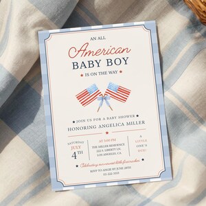 Könnte beinhalten: Eine rechteckige Babyparty-Einladungskarte mit cremefarbenem Hintergrund und hellblauem Karomuster am Rand. Der Text lautet An All American Baby Boy Is On The Way, ergänzt durch zwei gekreuzte amerikanische Flaggen mit einer hellblauen Schleife.