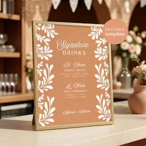 May include: A vertical rectangular sign in a gold frame featuring a terracotta background with white botanical leaf borders. The text reads Signature DRINKS, El Novio, TEQUILA MOJITO, La Novia, SPICY MARGARITA, and Antonio + Valeria. Includes an EDITABLE template tag.