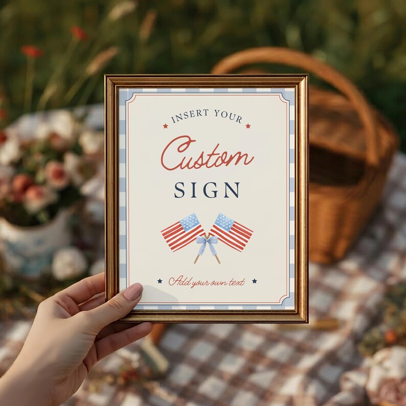 Hand holding framed customizable party sign at Fourth of July Americana celebration setup