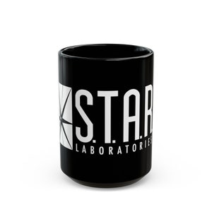 May include: Black ceramic mug with a white graphic of the "S.T.A.R. Laboratories" logo. The logo features a stylized lightning bolt.