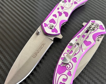 May include: A purple and silver pocket knife with a floral design and the word "WARTECH" on the blade.