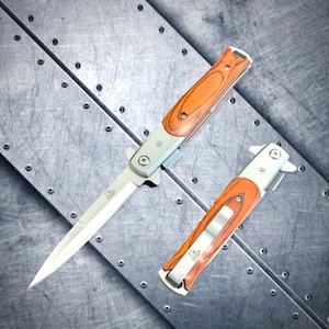 May include: Two folding pocket knives with wooden handles. The knives have a silver blade and a silver handle with a wood inlay. The knives are on a silver background.