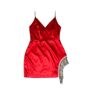 May include: A red satin mini dress with a V-neckline and spaghetti straps. The dress has a rhinestone trim on the straps and a rhinestone fringe on the side.