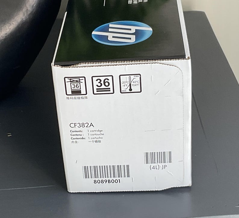 May include: A white and black HP printer cartridge box. The box has the model number CF382A and includes the text "Contents: 1 cartridge". The box also displays a barcode and the number "36".
