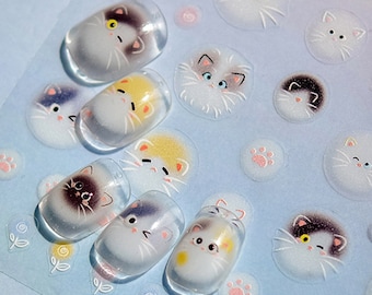 May include: A sheet of clear nail stickers with various cute cat faces. The stickers are in a variety of colors, including white, black, gray, and yellow. The stickers are perfect for adding a touch of whimsy to your nails.