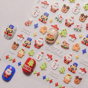 May include: A sheet of Christmas nail stickers with a variety of designs, including Santa Claus, Christmas trees, gingerbread men, and nutcrackers. The stickers are on a clear background and are ready to be applied to nails.
