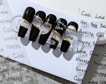 May include: Set of six black press-on nails with gold accents and white lettering. The nails feature the words "Sweet Love", "Happy Smoking", "Sweet Love", "OK", and "Cool".