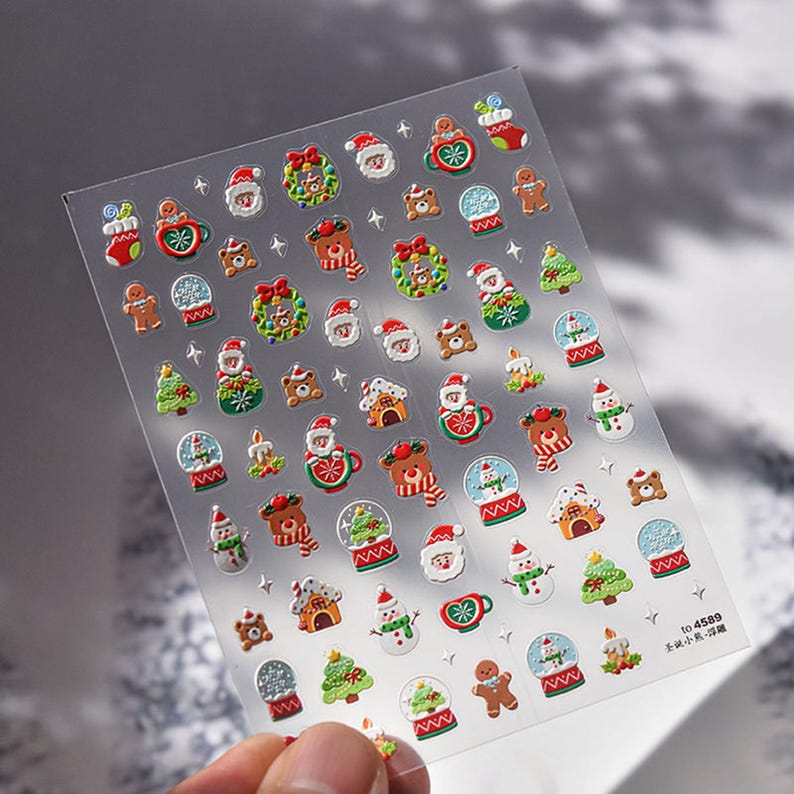 May include: A sheet of clear plastic with 3D Christmas stickers. The stickers feature a variety of festive designs, including snowmen, reindeer, Santa Claus, gingerbread men, and Christmas trees. The stickers are perfect for adding a touch of holiday cheer to crafts, gifts, and home decor.