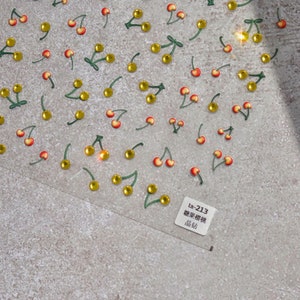 May include: A sheet of clear adhesive stickers with a repeating pattern of red cherries with green stems and yellow leaves. The sheet has the text "ta-213  樱桃贴纸  贴纸  162" printed on it.