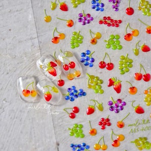Pu&ograve; includere: Un foglio di adesivi per unghie di frutta colorati con ciliegie, uva e fragole. Gli adesivi sono disposti in file e sono pronti per essere applicati sulle unghie. Gli adesivi sono trasparenti e hanno una finitura lucida.