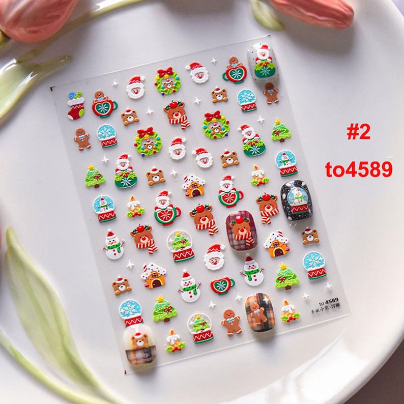 May include: A sheet of Christmas-themed nail stickers with a variety of designs, including snowmen, reindeer, gingerbread men, and Christmas trees. The stickers are on a clear background and are ready to be applied to nails. #2 to4589